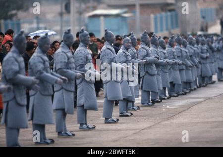 Hommes vêtus de soldats en terre cuite attendant de saluer la Reine Elizabeth II près du mausolée du premier empereur Qin, district de Lintong, Shaanxi, CH Banque D'Images