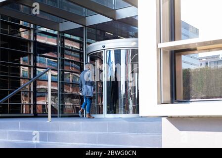 Jeune cadre entrant dans un immeuble de bureaux Banque D'Images