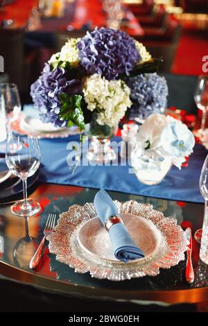 Table magnifiquement servie avec plats et fleurs Banque D'Images