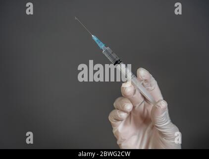 Vaccin contre le coronavirus COVID-19. Médecin scientifique avec seringue analyser le virus SRAS-CoV-2 en recherche pour le vaccin pour être prêt pour l'essai clinique. Femme Banque D'Images