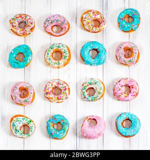 Donuts colorés turquoise et rose, motif. Beignets sur fond blanc. Beignets aux glaçure multicolore. Les beignets sont des pâtes douces traditionnelles Banque D'Images