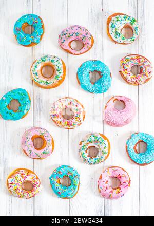 Donuts colorés turquoise et rose, motif. Beignets sur fond blanc. Beignets aux glaçure multicolore. Les beignets sont des pâtes douces traditionnelles Banque D'Images