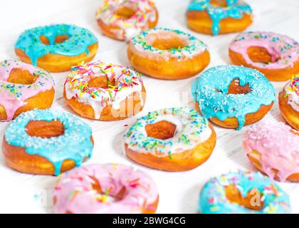 Donuts colorés turquoise et rose, motif. Beignets sur fond blanc. Beignets aux glaçure multicolore. Les beignets sont des pâtes douces traditionnelles Banque D'Images