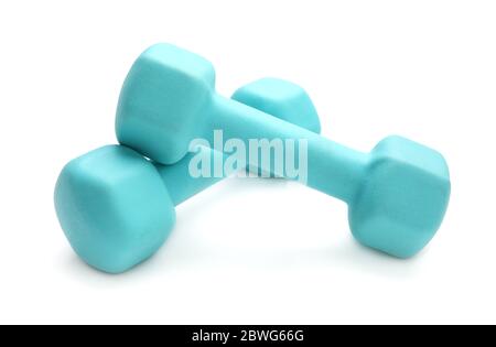 Deux haltères en caoutchouc de couleur turquoise, couchés sur une table blanche Banque D'Images