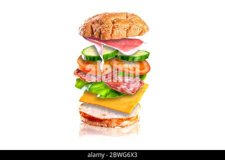 Sandwich savoureux volant. Sandwich avec des ingrédients volants isolés sur fond blanc. Banque D'Images