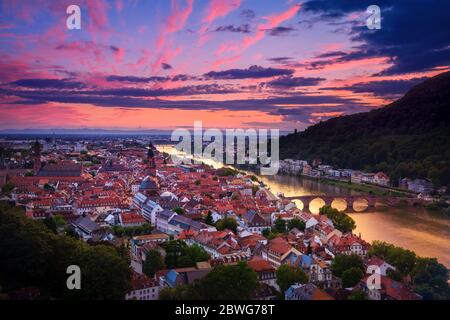 Vue aérienne romantique d'Heidelberg avec le Neckar, en Allemagne, une lueur spectaculaire avec des couleurs vives de rouge et de violet après le coucher du soleil Banque D'Images