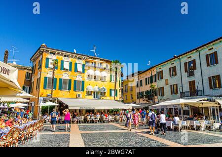 Sirmione, Italie, 11 septembre 2019: Rue piétonne Piazza Giogue place Carducci dans le centre historique de la ville avec des restaurants de rue et des bâtiments multicolores colorés, des touristes à pied, ciel bleu Banque D'Images