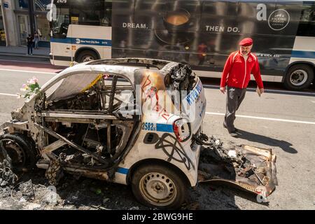 Le fondateur de Guardian Angel, Curtis Sliwa, inspecte un véhicule NYPD brûlé sur Broadway à Soho à New York après avoir vandalisé et pillé pendant les manifestations de la nuit précédente liées à la mort de George Floyd, vu le dimanche 31 mai 2020. (© Richard B. Levine) Banque D'Images