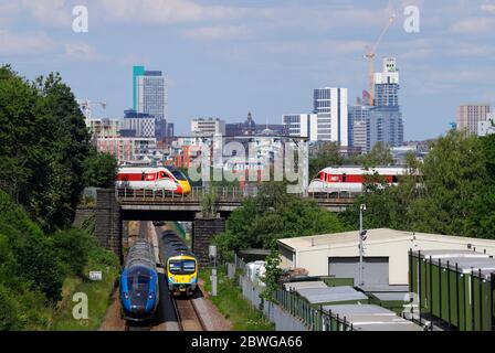 Image composite de trains passant par et sous un pont ferroviaire à Leeds. Le plus récent bâtiment du Yorkshire, Altus House, est en construction Banque D'Images