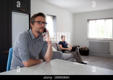 Homme travaillant de la maison dans la cuisine Banque D'Images