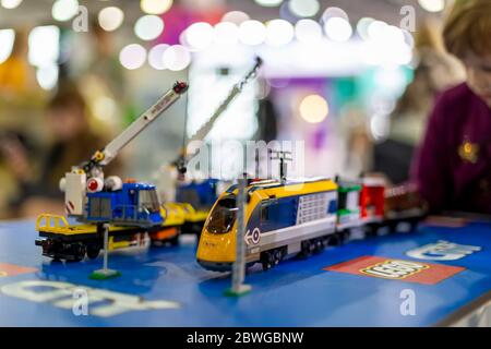 Moscou, Russie - 04 octobre 2019: Jaune électrique lego train avec grues. En arrière-plan l'enfant joue avec lui dans le flou Banque D'Images