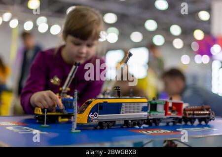 Moscou, Russie - 04 octobre 2019: Jaune électrique lego train avec grues. En arrière-plan l'enfant joue avec lui dans le flou Banque D'Images
