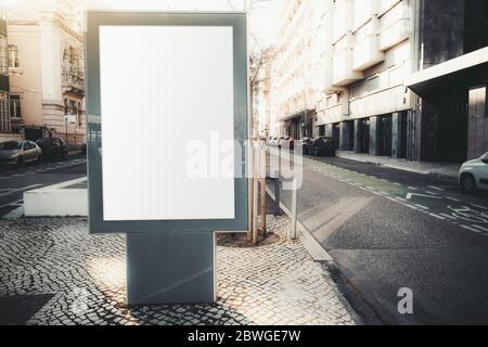 Maquette d'un panneau publicitaire vierge en milieu urbain ; un modèle de bannière de rue verticale vide sur la pierre pavée du trottoir ; une affiche extérieure Banque D'Images