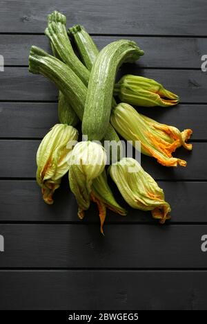 Concept des légumes. Courgettes fraîches avec fleur isolée sur une table en bois. Vue de dessus, espace de copie. Banque D'Images