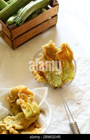 Fleurs de courgettes frites dans une pâte isolée sur fond clair. Vue de dessus. Concept des légumes. Banque D'Images