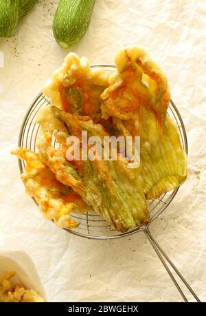 Fleurs de courgettes frites dans une pâte isolée sur fond clair. Vue de dessus. Concept des légumes. Banque D'Images