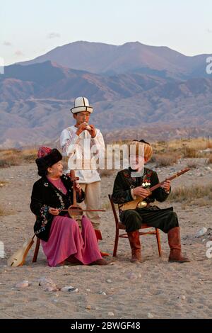 Musiciens kirghizes jouant des instruments traditionnels. Homme en blanc pièces Choor, dame joue Kyl Kiak, homme assis joue Komuz, à Issyik Kul, Kirghizistan Banque D'Images
