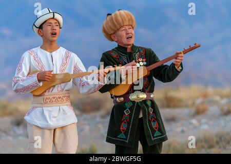 Musiciens kirghizes jouant un instrument de musique traditionnel connu sous le nom de Komuz, à Issyik Kul, Kirghizistan Banque D'Images