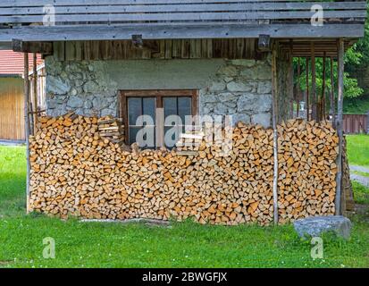 Maison avec bois de chauffage frais superposés en Bavière Banque D'Images