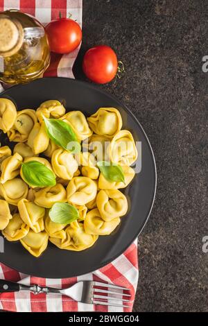 Pâtes tortellini. Pâtes italiennes farcies aux feuilles de basilic sur l'assiette. Vue de dessus. Banque D'Images