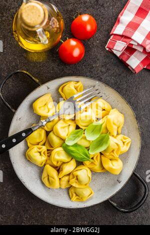 Pâtes tortellini. Pâtes italiennes farcies aux feuilles de basilic sur la casserole. Vue de dessus. Banque D'Images