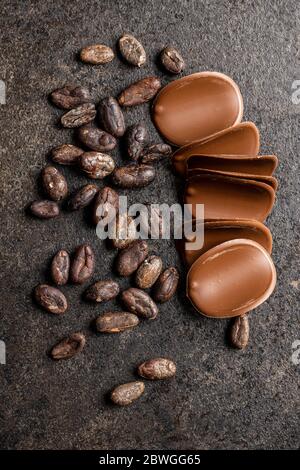 Grains de chocolat noir et de cacao sur table noire. Vue de dessus. Banque D'Images