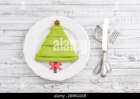 Serviette en forme d'arbre de Noël avec étoile anisée et bâton de cannelle comme tronc d'arbre sur l'assiette, vue du dessus Banque D'Images