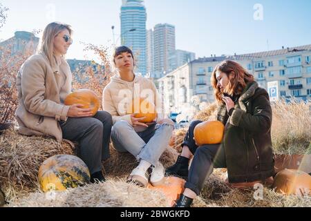 Les filles tient les citrouilles dans les mains sur le fond de la rue. Banque D'Images