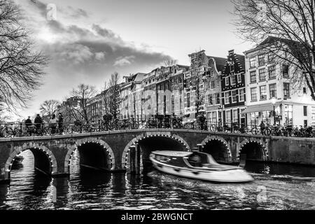 Belle scène tranquille de ville d'Amsterdam au crépuscule. Les vélos le long de la rue et sur le pont sur le canal. Banque D'Images