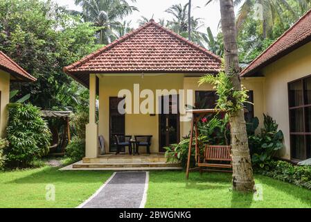 BALI, INDONÉSIE - 14 JANVIER 2018: Territoire Discovery Candidasa Cottages and Villas Hôtel avec chaises suspendues en osier à la journée ensoleillée, Bali, Indonésie Banque D'Images