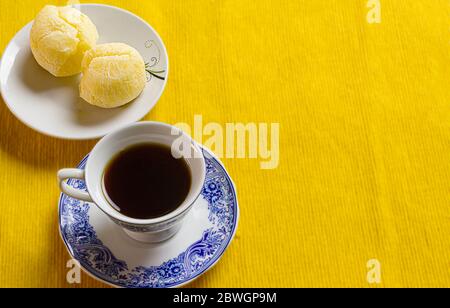 Tasse de café et pain au fromage brésilien sur le napperon jaune. Banque D'Images