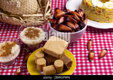 Cuisine et friandises typiques de la junina brésilienne. Couscouz, bonbons aux arachides, riz doux, dulces de leche et pignons de pin. Banque D'Images