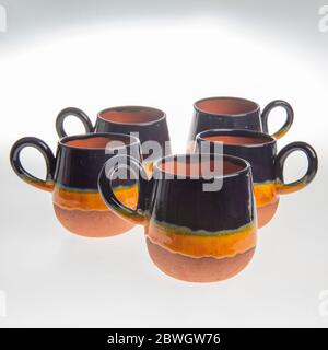 tasses en céramique faites main colorées sur fond blanc Banque D'Images