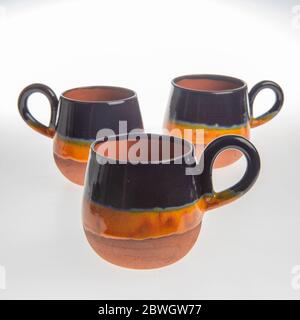 tasses en céramique faites main colorées sur fond blanc Banque D'Images