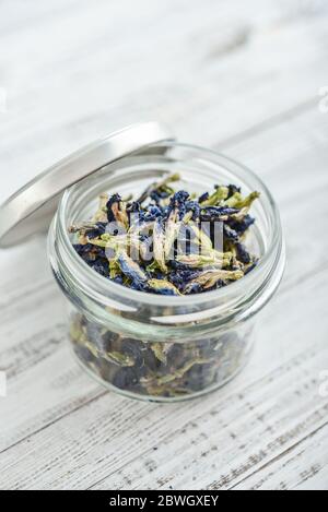 Fleurs de Clitoria séchées dans un pot sur fond blanc en bois gros plan Banque D'Images