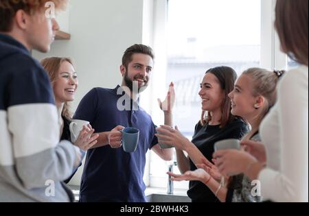 Groupe d'hommes et de femmes heureux en conversation pendant la consommation de thé Banque D'Images