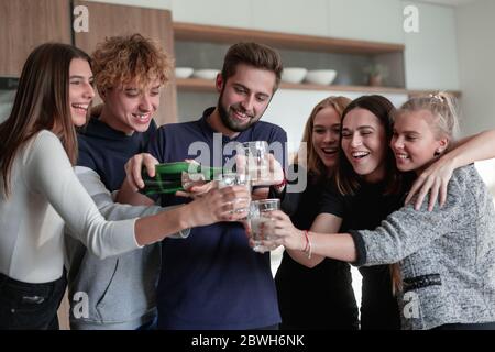 Une bouteille de champagne à l'ouverture pour les jeunes amis Banque D'Images