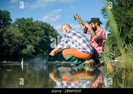 Pêche au gros gibier. Week-end d'été. Deux pêcheurs se détendent ensemble avec de la bière tout en pêchant sur le lac le matin. Baiter principal. Week-ends de pêche Banque D'Images