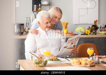 Un couple de personnes âgées heureux prenant le petit déjeuner à la maison Banque D'Images