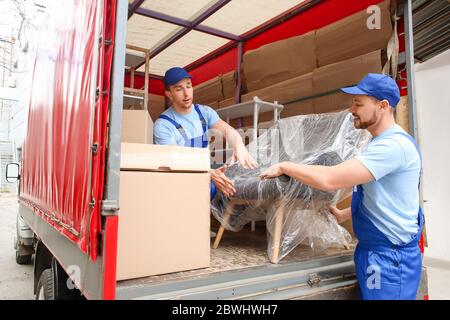 Les chargeurs prennent les meubles des camions à l'extérieur Banque D'Images