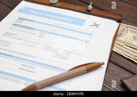 Formulaire d'assurance voyage avec de l'argent sur la table Banque D'Images