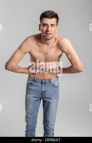Jeune homme avec anorexie sur fond gris Banque D'Images