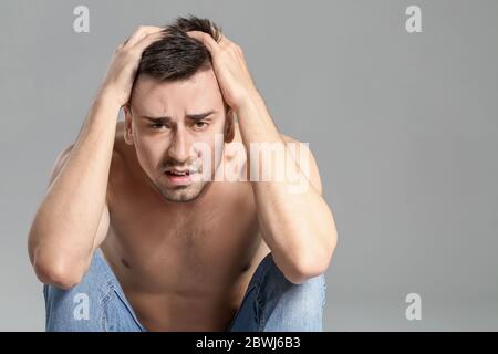 Jeune homme avec anorexie sur fond gris Banque D'Images