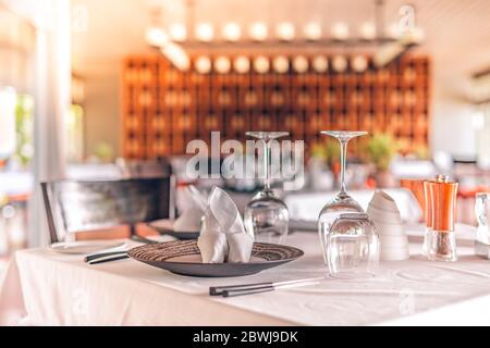 Restaurant élégant, table avec intérieur flou, lumières et chaises, tables et verres à vin Banque D'Images