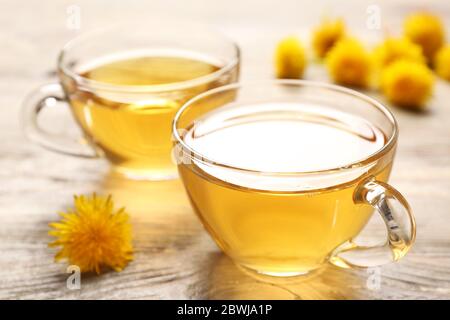 Tasses de thé sandelion sain sur fond de bois Banque D'Images