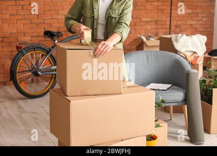 Woman packing déménagement fort à la maison Banque D'Images
