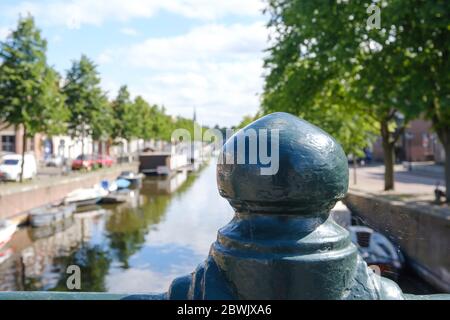 La Haye, pays-Bas - Mai 15 2020: Canal avec réflexion de bateaux et d'arbres, rue remplie de voitures et de maisons. Focus en premier plan, dans le Banque D'Images