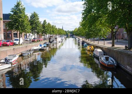 La Haye, pays-Bas - Mai 15 2020 : Canal avec réflexion de bateaux et d'arbres, rue remplie de voitures et de maisons à la Haye, pays-Bas Banque D'Images