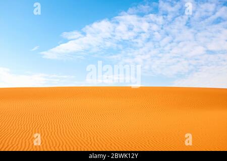 Le motif de sable blanc orange vif se déforme pour un arrière-plan chaud en été. Banque D'Images