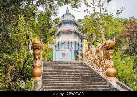 Petit temple bouddhiste vietnamien avec dragons dans la forêt Banque D'Images